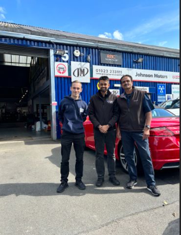 BookMyGarage employee posing for photo outside Johnson Motors with garage owner
